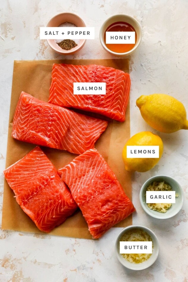 Ingredients measured out to make Honey Lemon Garlic Salmon: salt, pepper, honey, salmon, lemons, garlic and melted butter.