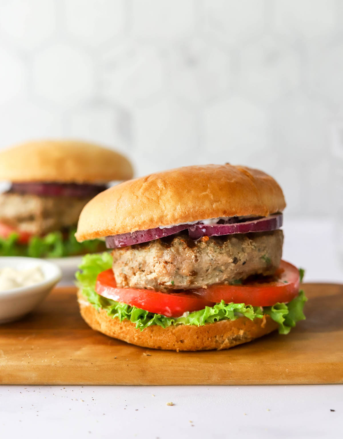 Turkey burger assembled on a bun with tomato, lettuce and red onion.