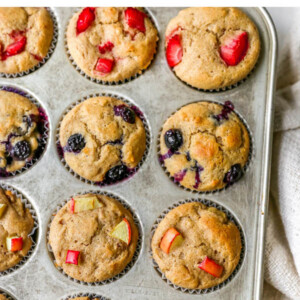 Overhead view of 4 rows of yogurt muffins. Each row contains a different type of yogurt muffin: strawberry, blueberry, apple and chocolate chip.