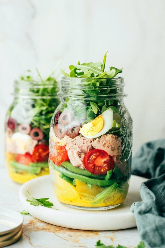 PIN THIS —> Meal Prep Tuna Nicoise Salad A mason jar containing layers of Nicoise salad ingredients.