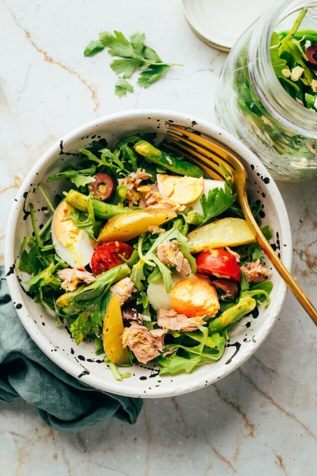 Pin This --> Meal Prep Nicoise Salad! Nicoise salad in a serving bowl with a fork.