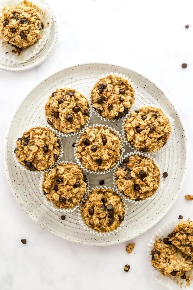Overhead view of 8 oatmeal cups wrapped in paper liners organized on a plate.