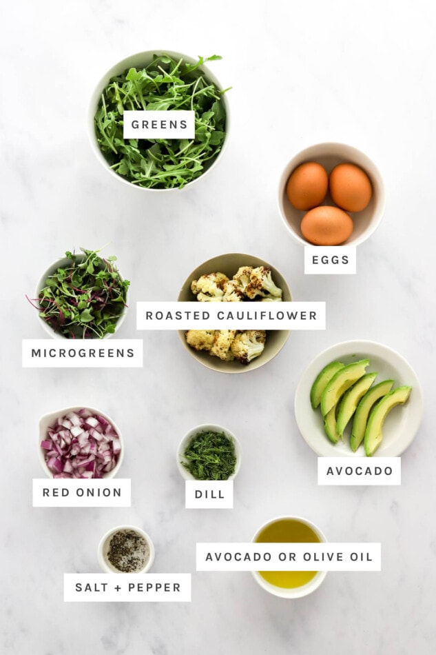 PIN THIS --> Breakfast Salad with Sautéed Greens and Two Fried Eggs Ingredients measured out to make a breakfast salad: greens, eggs, microgreens, roasted cauliflower, avocado, red onion, dill, salt, pepper and oil.
