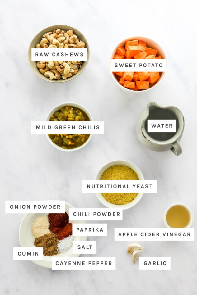 Ingredients measured out to make vegan queso: raw cashews, sweet potato, mild green chilis, water, nutritional yeast, onion powder, chili powder, paprika, salt, cumin, cayenne pepper, vinegar and garlic.