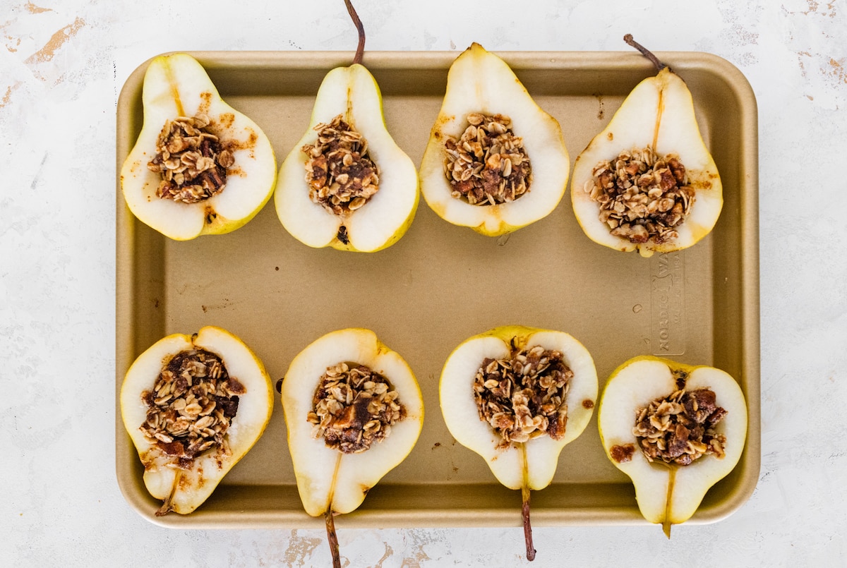 Pears lined up on a baking sheet.