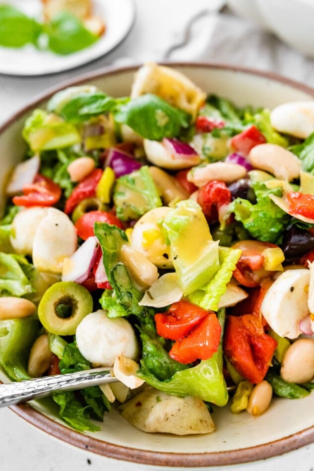 Antipasto salad served in a bowl with a fork.