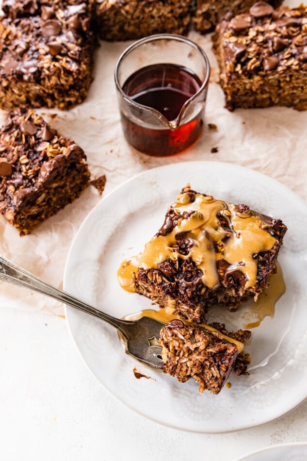 A portion of cauliflower brownie baked oatmeal on a plate, a fork has a bite removed.