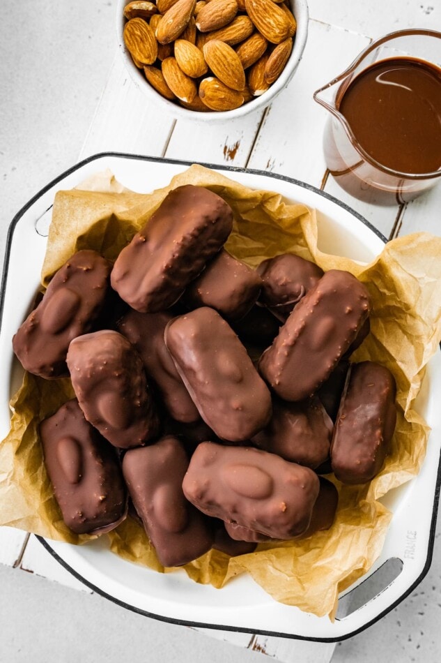Homemade almond joy bars in a bowl lined with parchment paper.