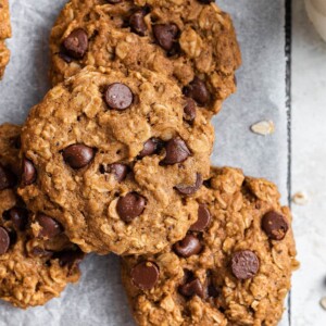 Overhead view of a few chocolate chip oatmeal cookies stacked around each other.