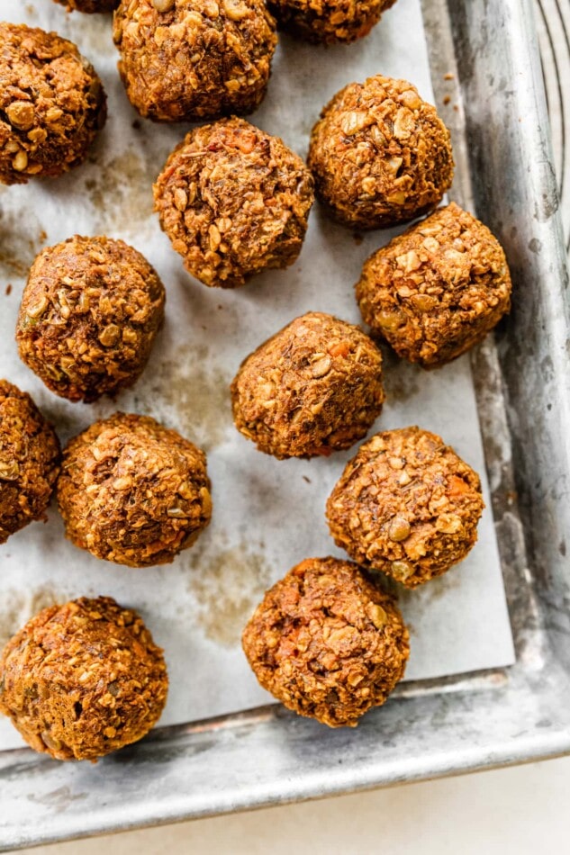 Vegan lentil meatballs on a sheet pan lined with parchment paper.