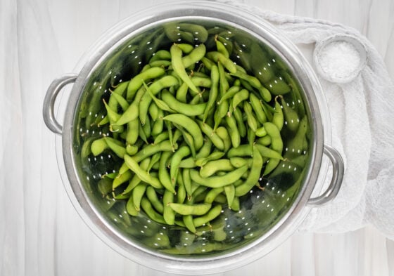 Cooked edamame in a strainer.