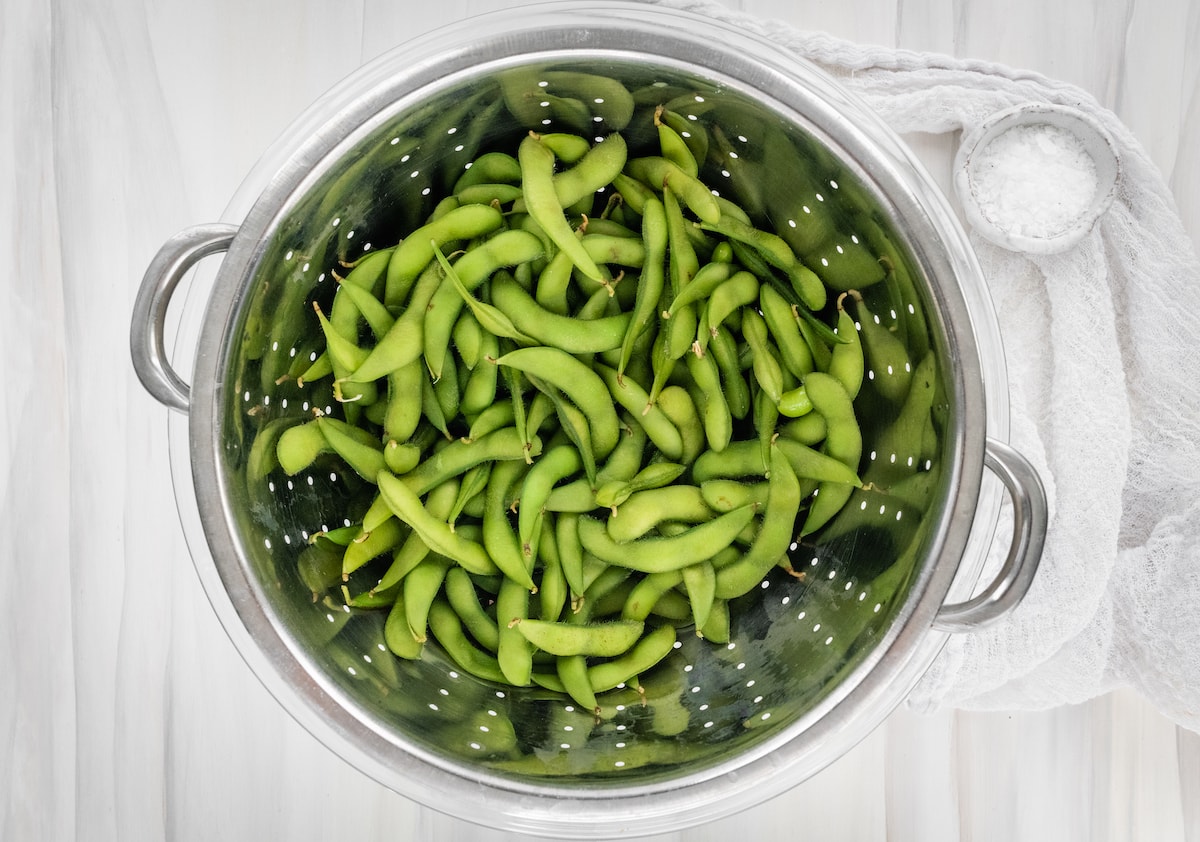 Cooked edamame in a strainer.