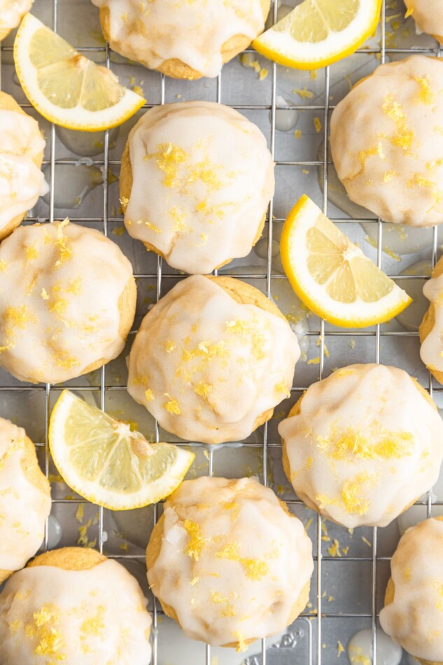 Cookies and lemon wedges on a wire cooling rack.