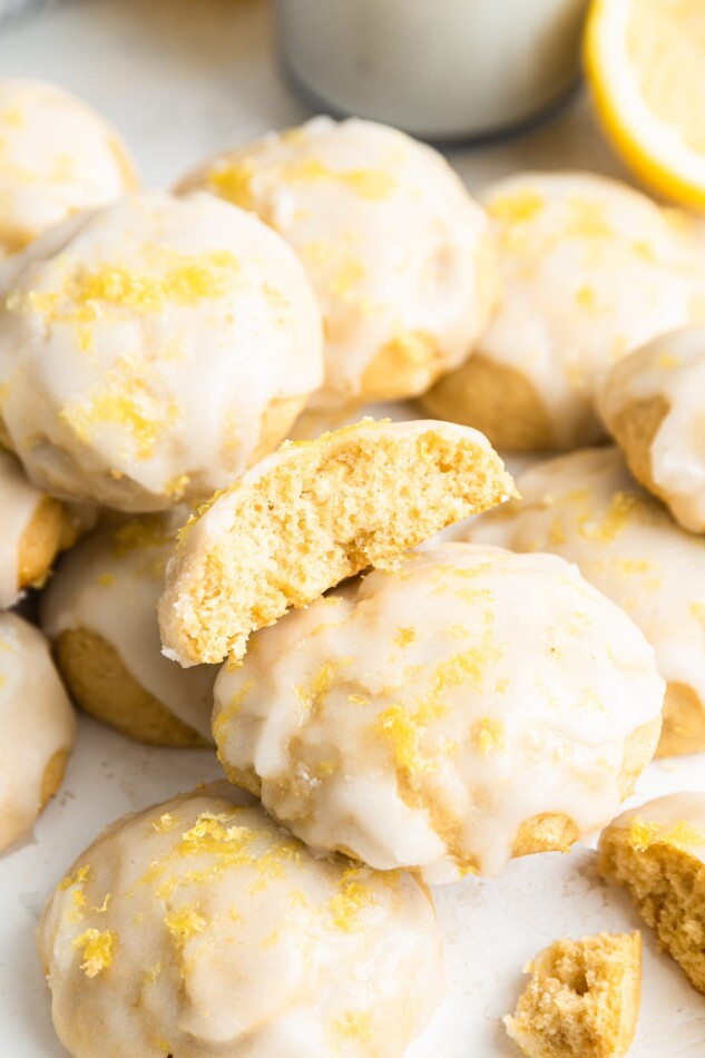 A lemon ricotta cookie cut in half with the inside exposed resting on top of other cookies.