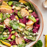 A salad bowl containing pear and beet salad.