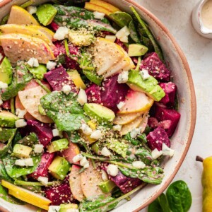 A salad bowl containing pear and beet salad.