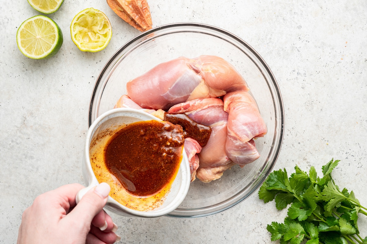 Pouring the marinade over the chicken breasts.