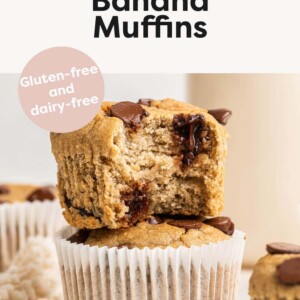 Two chocolate chip banana muffins stacked, the top has a bite taken out of it.