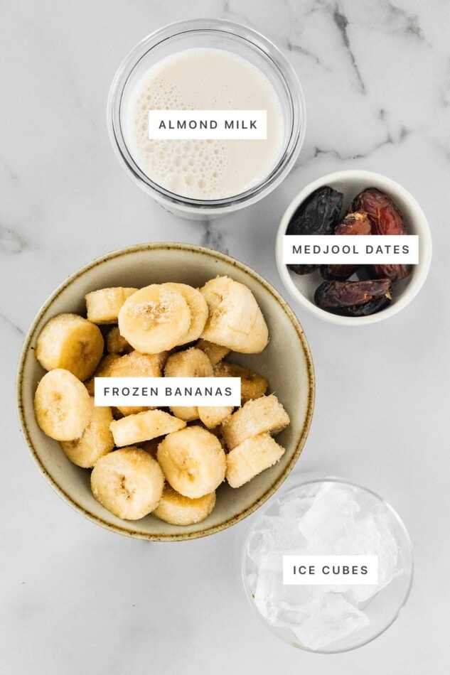 This healthy date shake is made with frozen bananas instead of ice cream and requires only four simple ingredients. It's dairy-free, gluten-free and vegan. Ingredients measured out to make a Date Shake: almond milk, medjool dates, frozen banana and ice cubes.