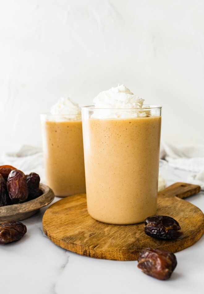 This healthy date shake is made with frozen bananas instead of ice cream and requires only four simple ingredients. It's dairy-free, gluten-free and vegan. Two glasses containing healthy date shake.