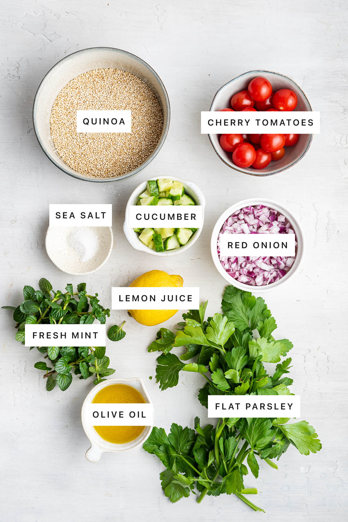 Ingredients measured out to make Quinoa Tabbouleh: quinoa, cherry tomatoes, cucumber, sea salt, red onion, lemon, fresh mint, parsley and olive oil.
