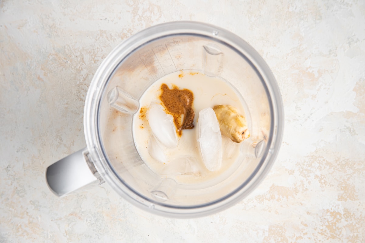 Ingredients for banana almond butter smoothie in blender.