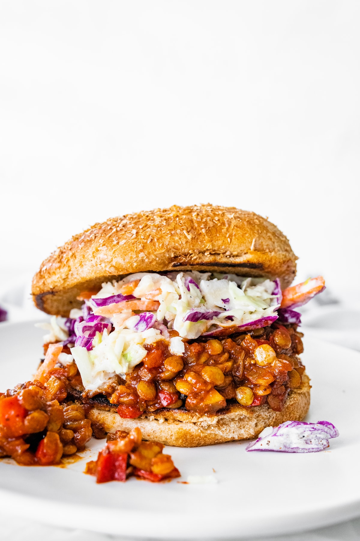One vegan Sloppy Joe on a whole wheat bun topped with coleslaw.