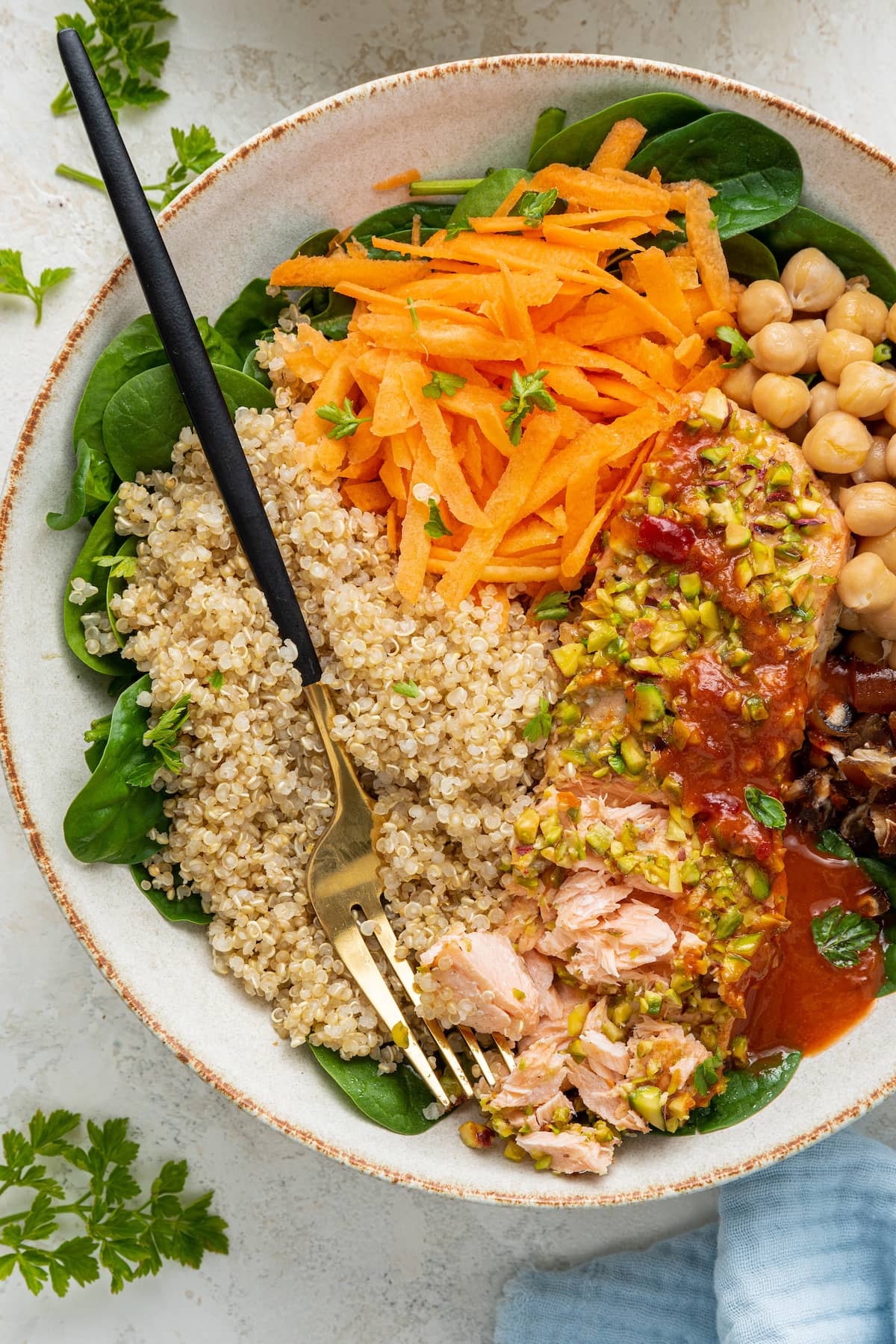A pistachio salmon salad is served in a white bowl with a fork.