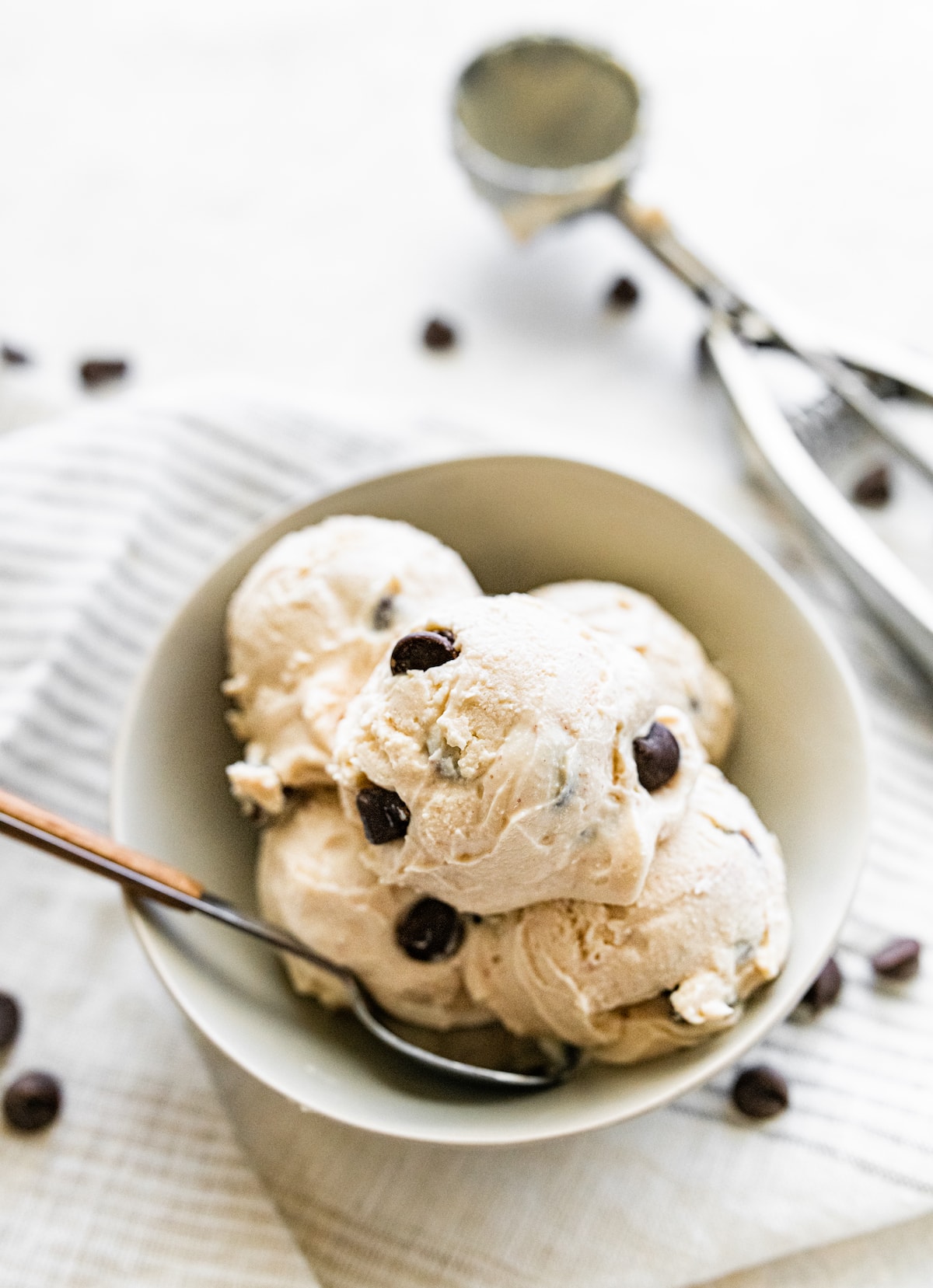 Scoops of cottage cheese ice cream in a bowl served with a spoon.