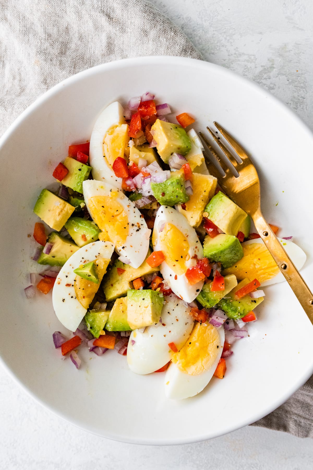 PIN THIS--> Egg and Avocado Bowl A serving of hard boiled eggs with avocado, red onion, red bell pepper, and topped with ground pepper.