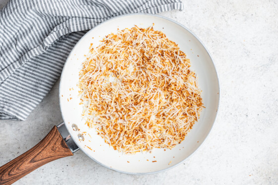 Coconut shreds in a white skillet.