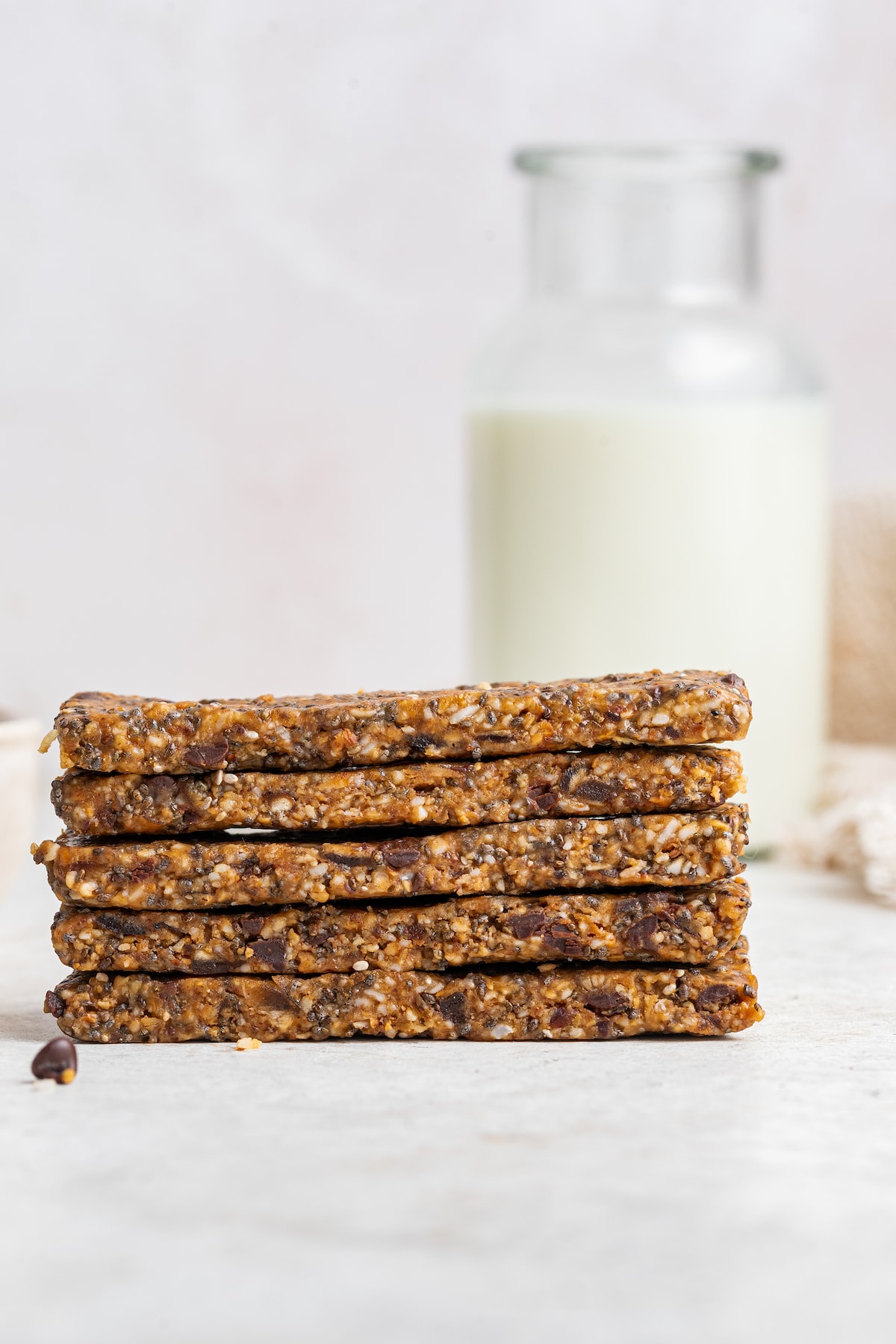Homemade toasted coconut chia bars. Five coconut chia bars stacked on one another.