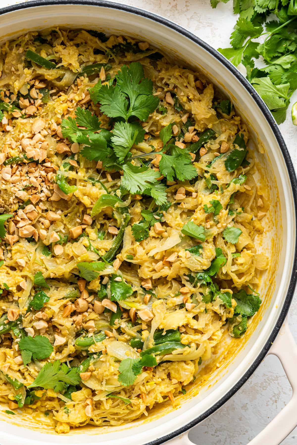 HEALTHY Pad Thai with Cabbage Noodles (low carb + gluten-free) Healthy Pad Thai in a large white pot garnished with fresh cilantro and peanuts.