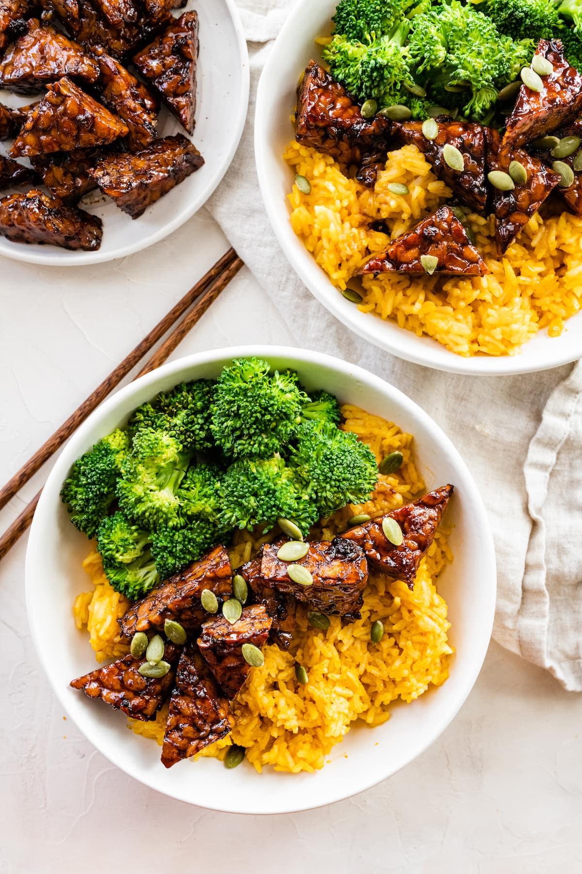 The BEST tempeh bowls --> Maple Balsamic Tempeh Bowls with creamy pumpkin rice and steamed broccoli Two bowls with maple balsamic tempeh, broccoli, pumpkin seeds, and pumpkin rice.