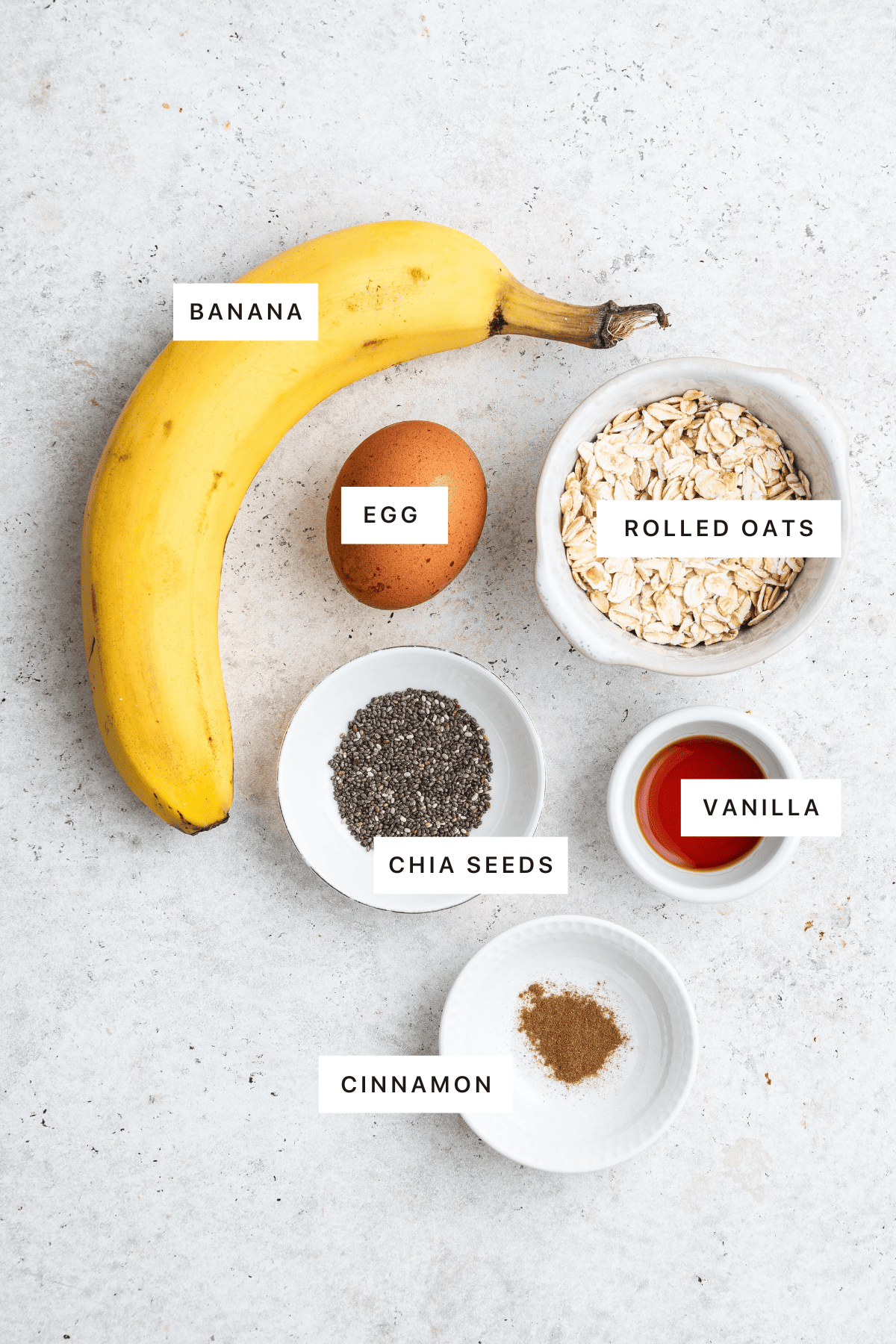 Ingredients measured out to make Scrambled Oats: banana, egg, rolled oats, chia seeds, vanilla and cinnamon.