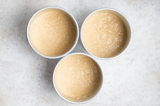 The vanilla cake batter separated in three circle cake pans.