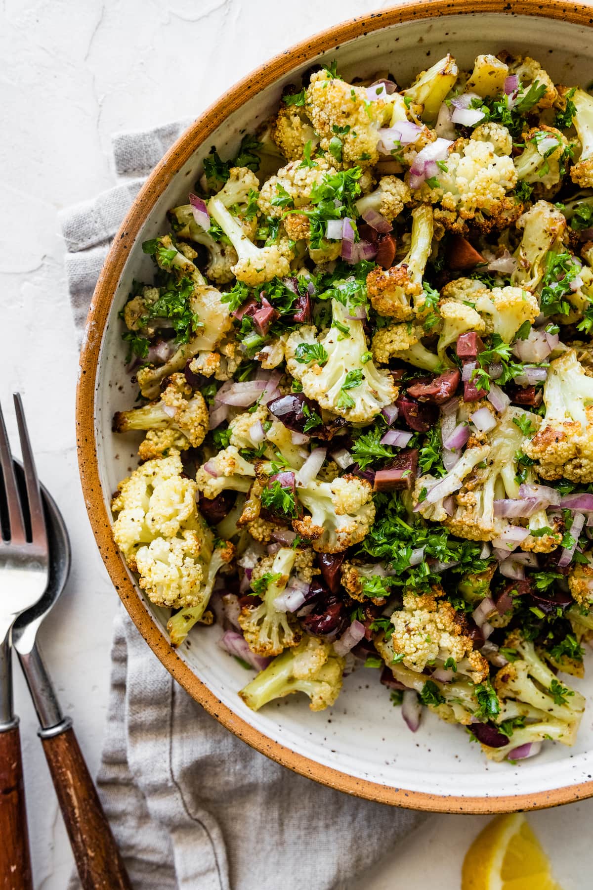 A serving of roasted cauliflower salad in fresh herbs and spices in a large bowl.