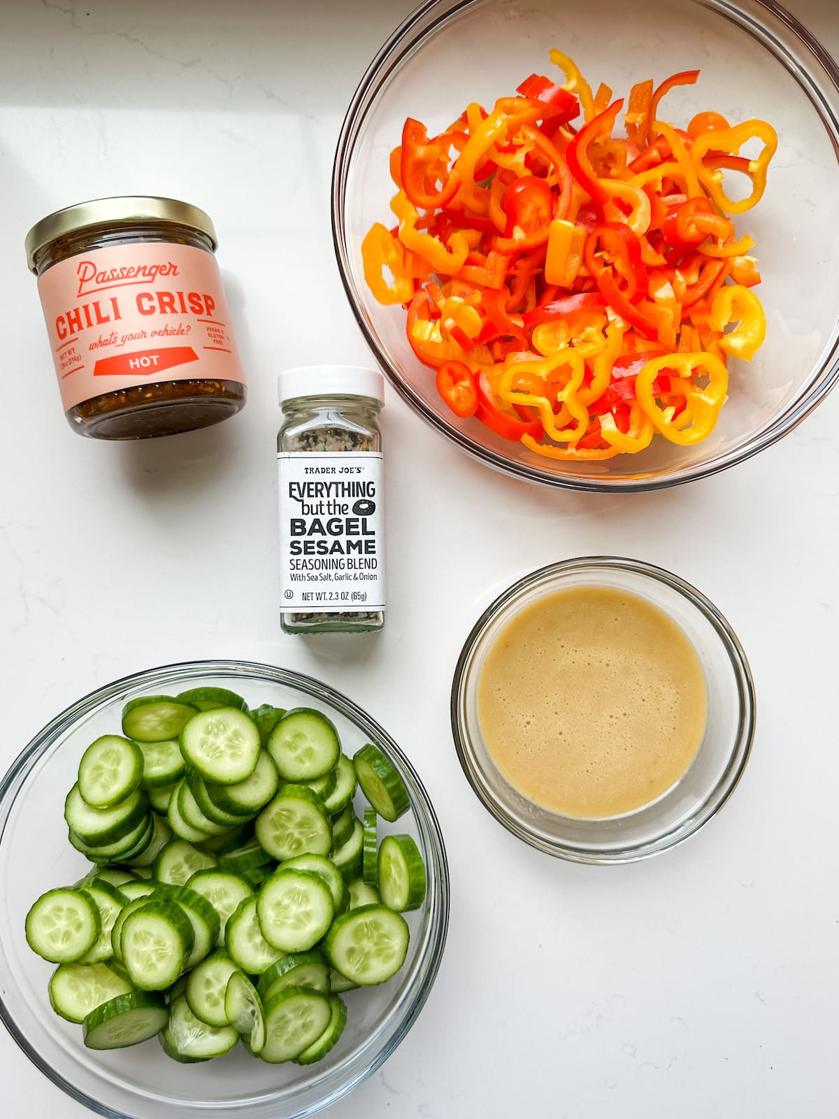Ingredient photo with cucumber, bell pepper, chili crisp, everything bagel seasoning and sesame ginger dressing.