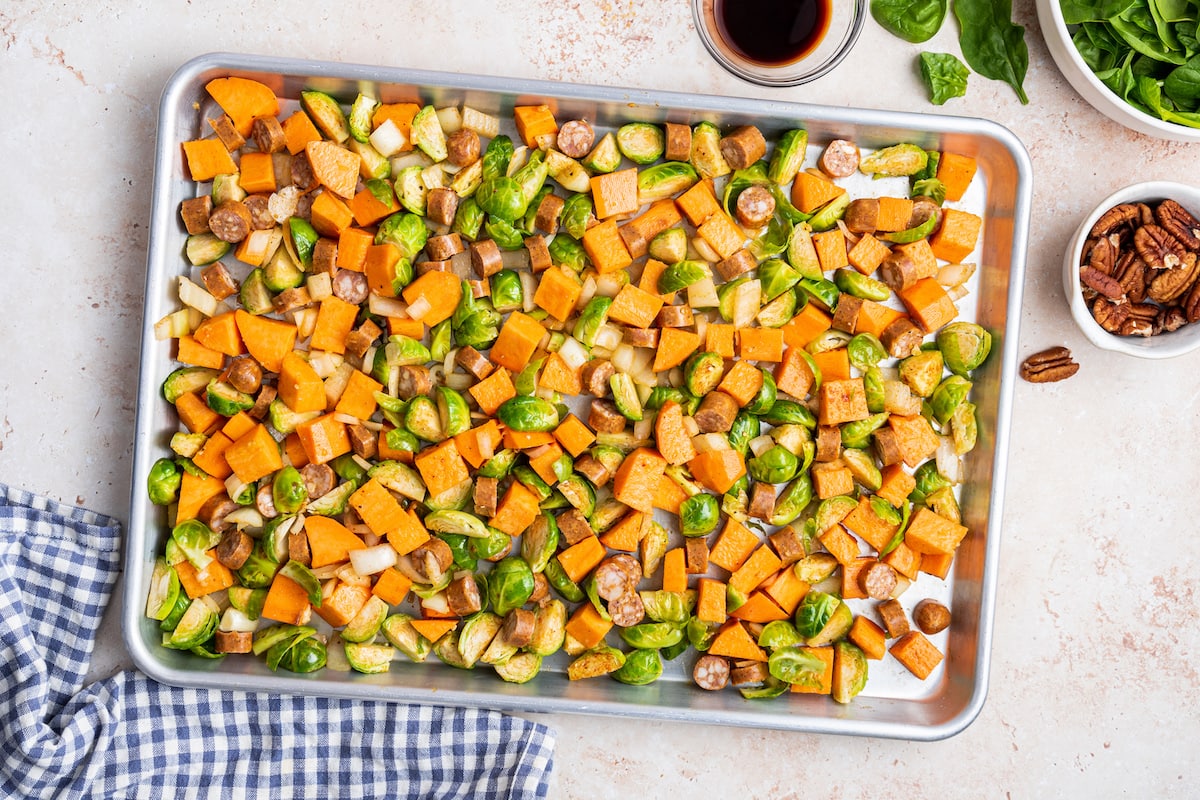 All the vegetables and sausage for the sweet potato hash on a baking tray before being baked.