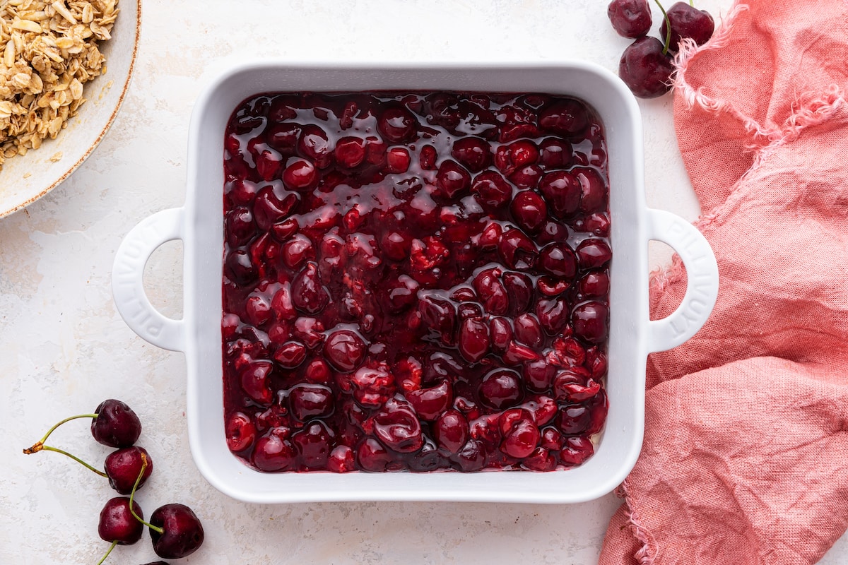Melted cherries in a large, square, baking dish.