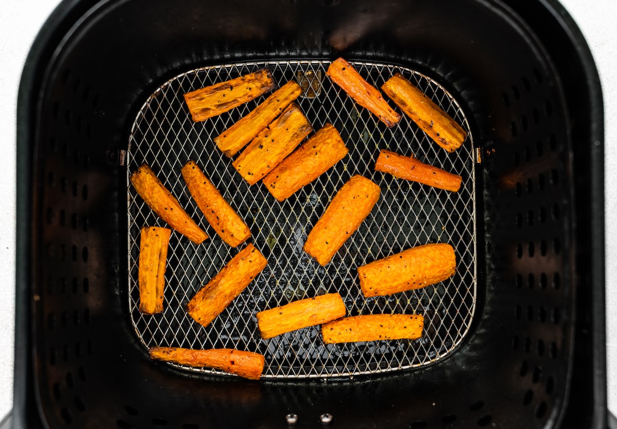 Carrots in an air fryer after being air fried.
