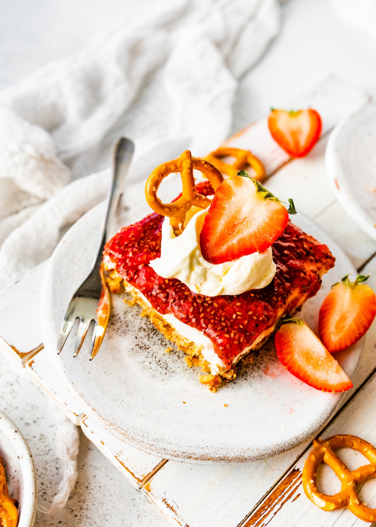 A slice of strawberry pretzel salad is served on a small plate.