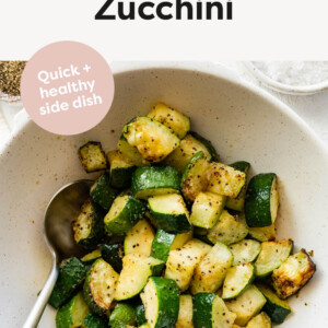 Bowl of Air Fryer Zucchini with a serving spoon.