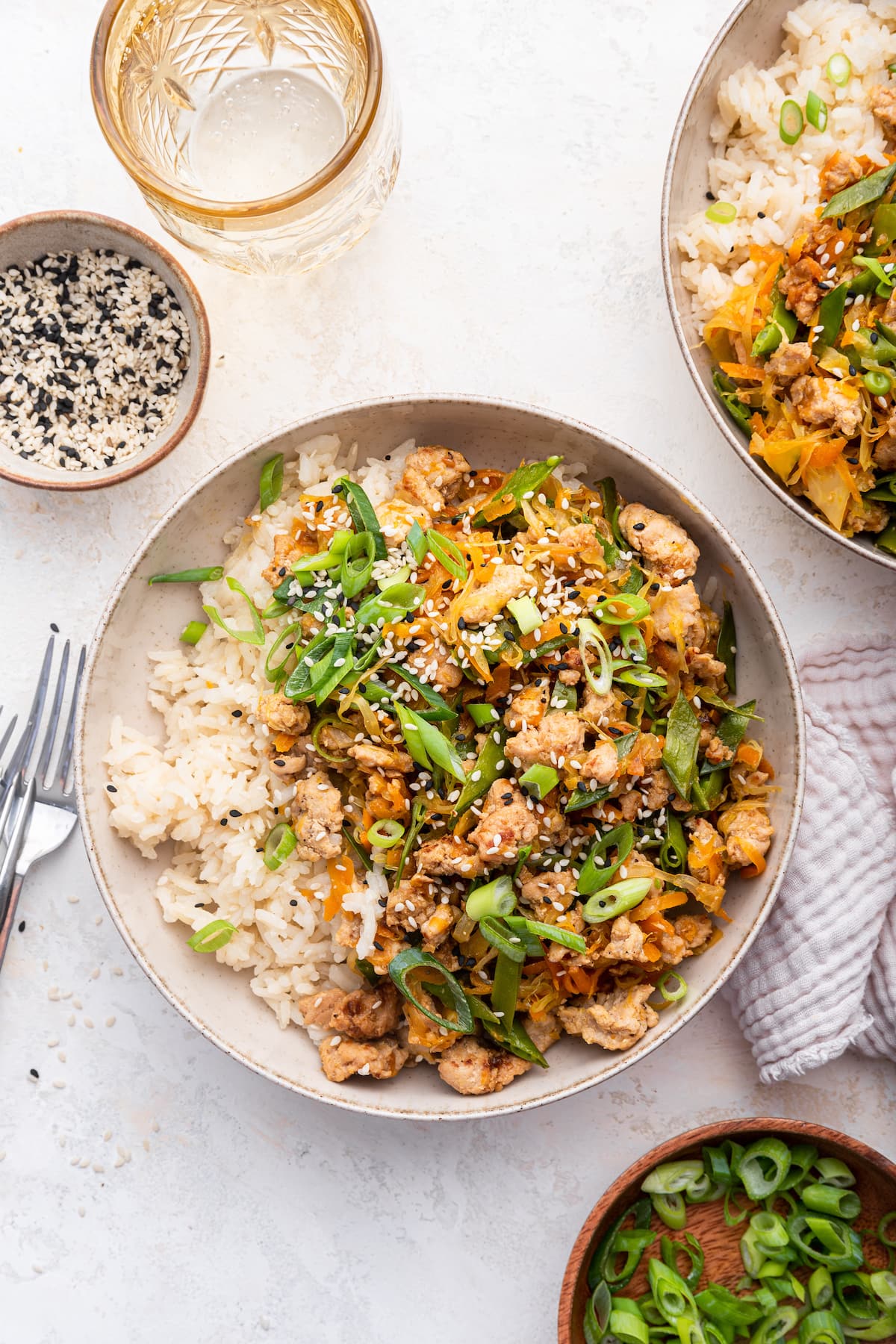 A serving of turkey, rice, green onion, and sesame seeds in a large bowl.