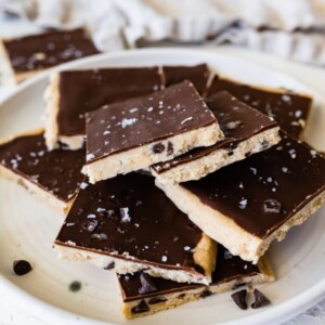 Protein cookie dough bark topped with flaked sea salt angled on a plate.
