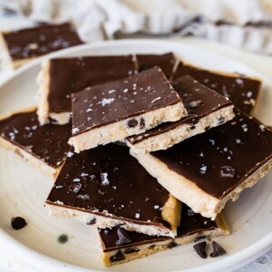 Protein cookie dough bark topped with flaked sea salt angled on a plate.