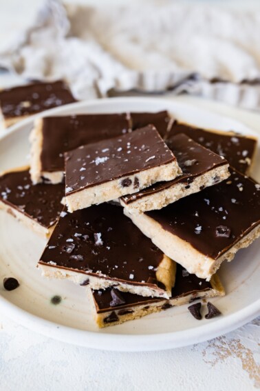 Protein cookie dough bark topped with flaked sea salt angled on a plate.