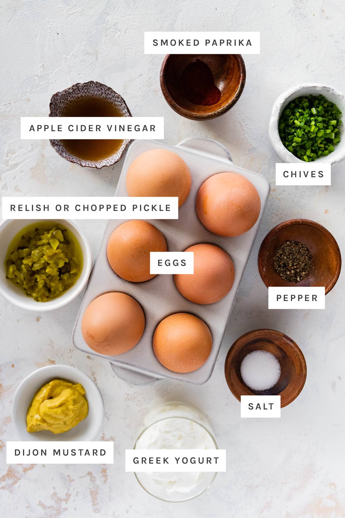 Ingredients used for deviled eggs include: eggs, chives, salt, pepper, greek yogurt, dijon mustard, relish, vinegar, and paprika.