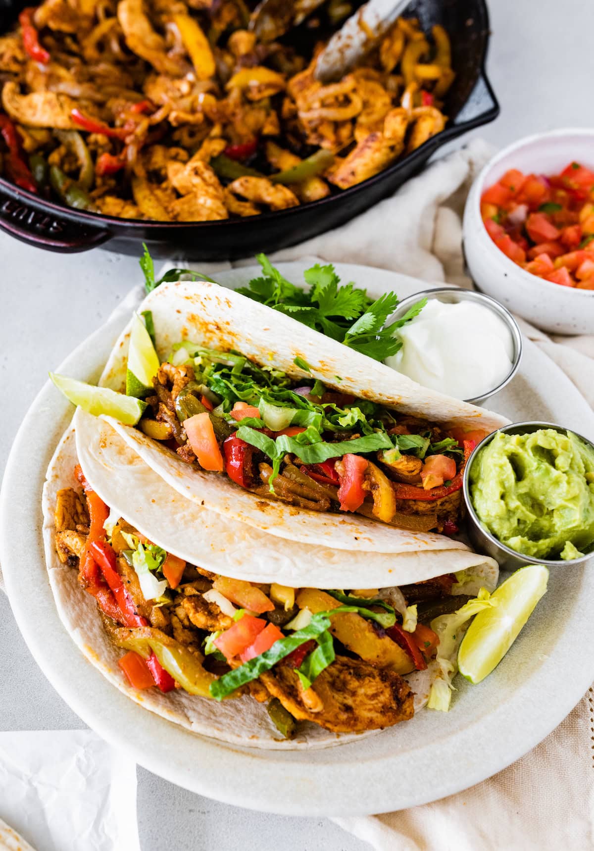 Chicken fajitas in two tortillas on a plate.