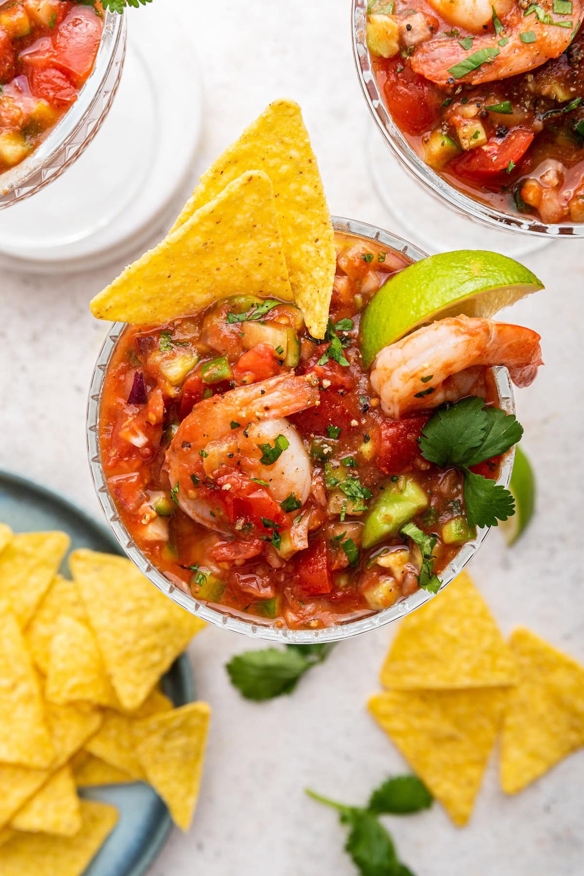 A mexican shrimp cocktail in a small glass with a tortilla chip.